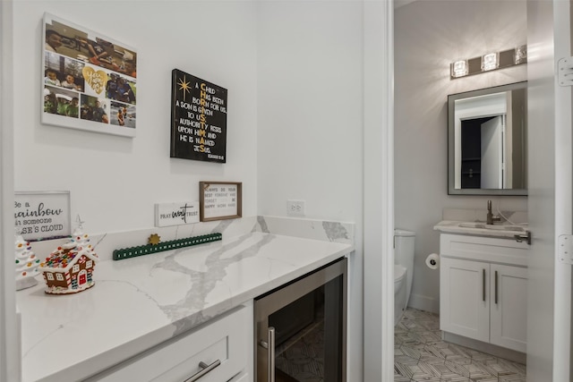 bathroom with wine cooler, vanity, and toilet