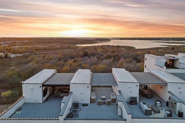 aerial view at dusk featuring a water view