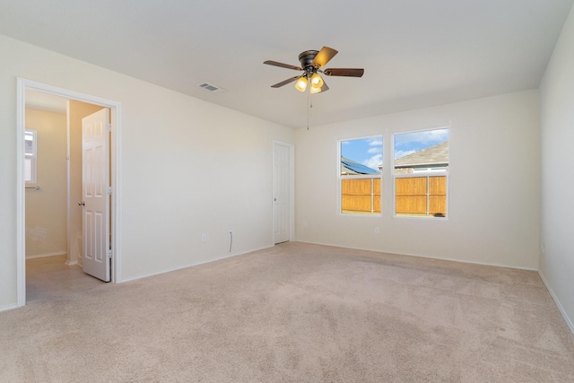 carpeted spare room with ceiling fan