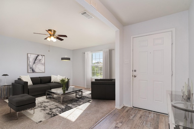 living room with ceiling fan and light hardwood / wood-style flooring