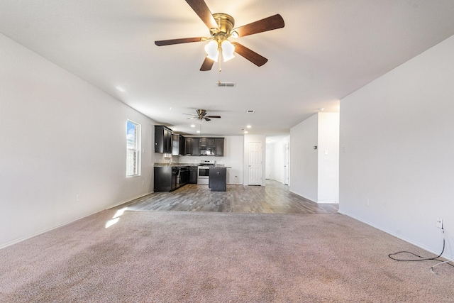 unfurnished living room with ceiling fan and light colored carpet