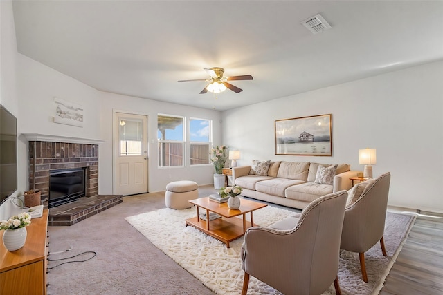 living room with ceiling fan and a fireplace