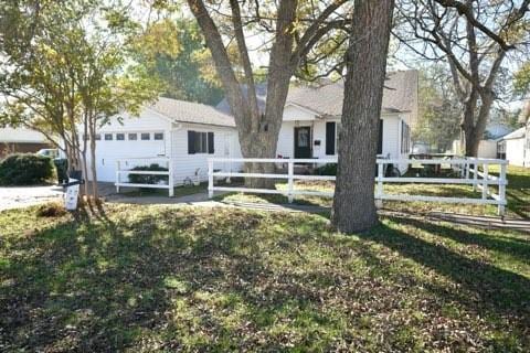 single story home featuring a garage and a front yard