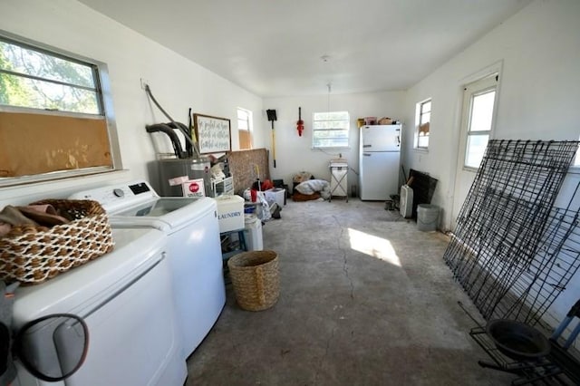 laundry area featuring gas water heater, a wealth of natural light, and washing machine and clothes dryer