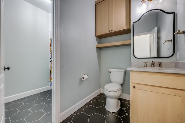 bathroom featuring tile patterned flooring, vanity, and toilet