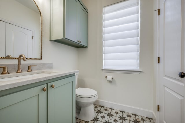 bathroom with tile patterned flooring, vanity, toilet, and a wealth of natural light