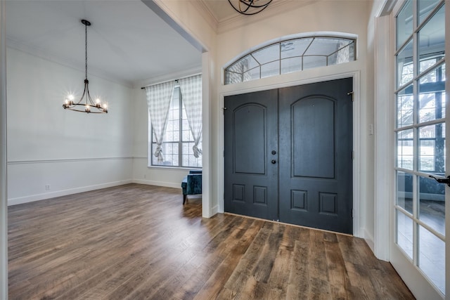 foyer featuring a chandelier, dark hardwood / wood-style flooring, and crown molding