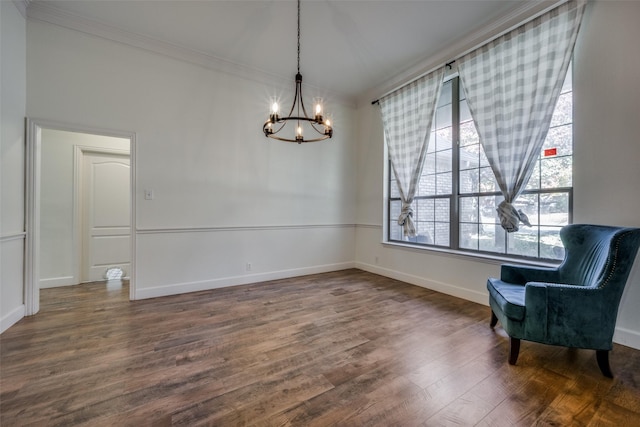 sitting room featuring hardwood / wood-style flooring, crown molding, and a notable chandelier