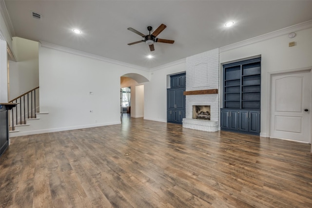 unfurnished living room with dark hardwood / wood-style floors, a brick fireplace, and ornamental molding