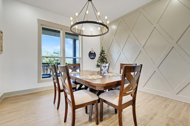 dining space with a notable chandelier and light hardwood / wood-style floors