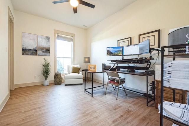 home office with light hardwood / wood-style flooring and ceiling fan