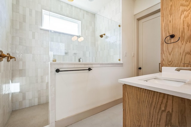 bathroom featuring vanity, tile patterned flooring, and a tile shower