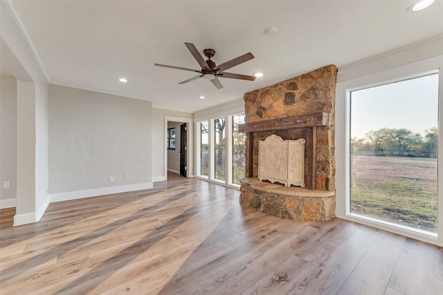 unfurnished living room featuring ornamental molding, ceiling fan, and light hardwood / wood-style flooring