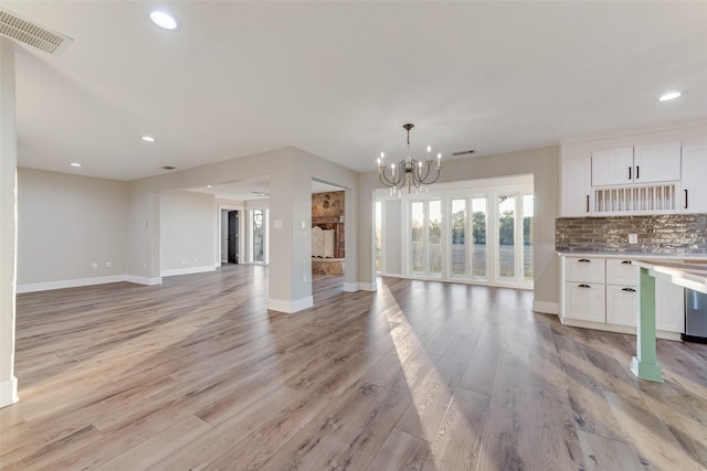 598 Dowell Rd, Rockwall, TX 75032 - unfurnished living room with baseboards, recessed lighting, light wood-style floors, and a chandelier
