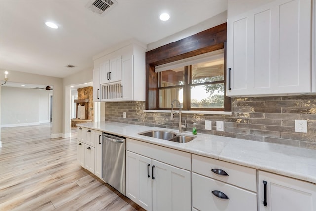 kitchen with white cabinetry, dishwasher, sink, backsplash, and light hardwood / wood-style flooring