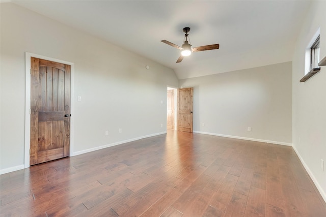 spare room with hardwood / wood-style flooring, lofted ceiling, and ceiling fan