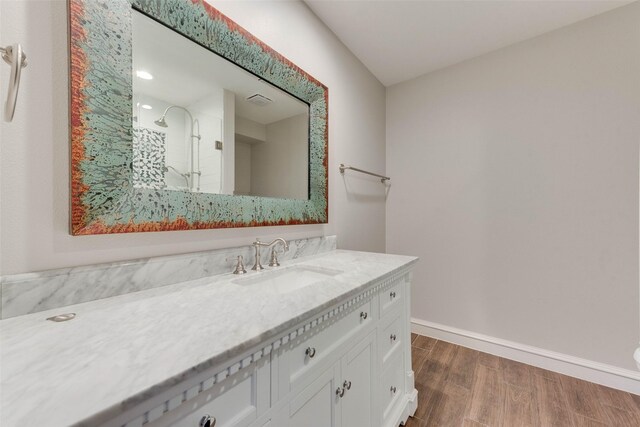 bathroom featuring wood-type flooring, vanity, and a shower