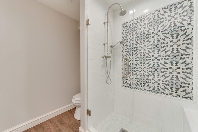 bathroom featuring hardwood / wood-style flooring, toilet, and walk in shower