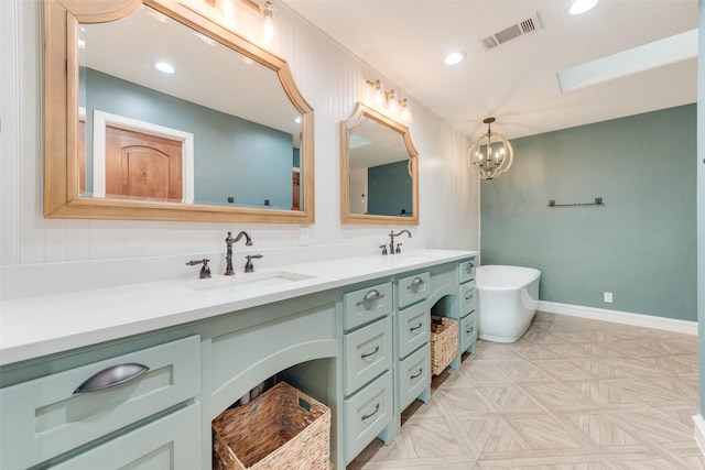 bathroom with vanity, parquet floors, a washtub, and a notable chandelier