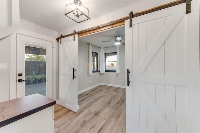 entrance foyer with a barn door and light wood-type flooring