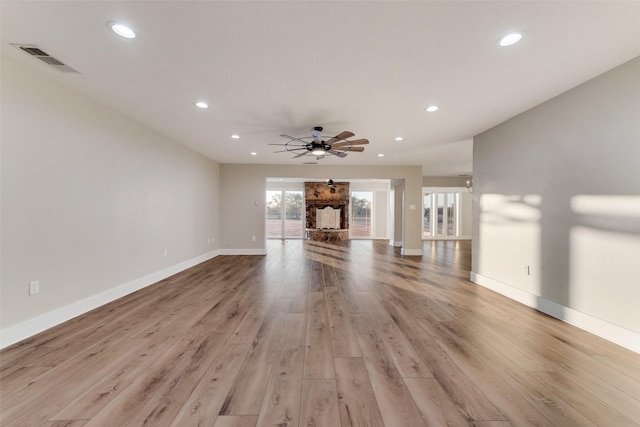 unfurnished living room with light hardwood / wood-style flooring and ceiling fan