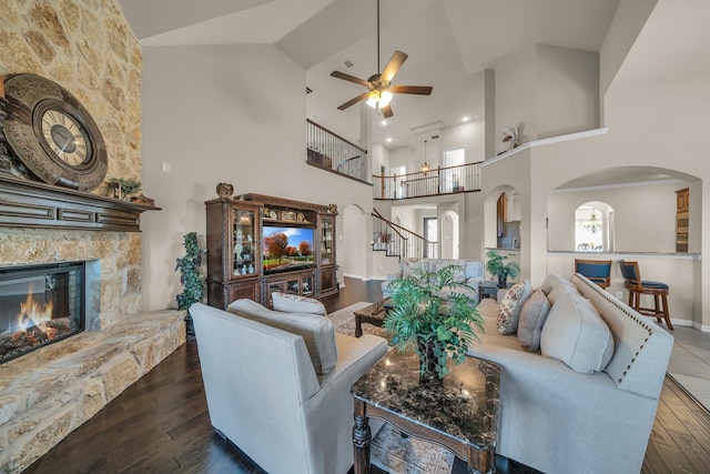 living room featuring ceiling fan, dark hardwood / wood-style flooring, a fireplace, and high vaulted ceiling