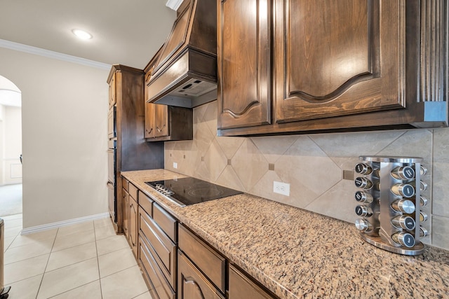 kitchen with backsplash, black electric cooktop, ornamental molding, light stone counters, and custom range hood