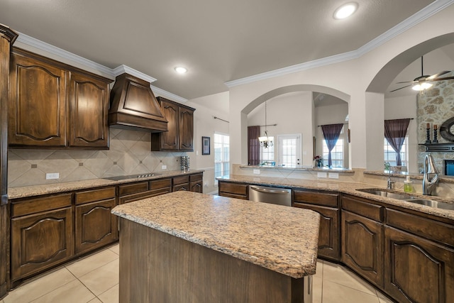 kitchen featuring premium range hood, crown molding, sink, dishwasher, and a center island