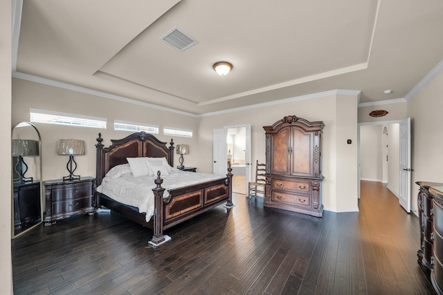 bedroom featuring a raised ceiling, connected bathroom, crown molding, and dark wood-type flooring