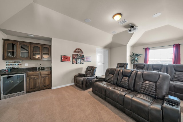 carpeted cinema with wine cooler, lofted ceiling, and indoor wet bar