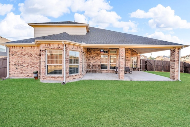 rear view of house with a lawn and a patio