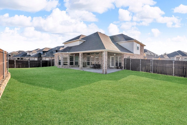 back of house featuring a lawn and a patio area