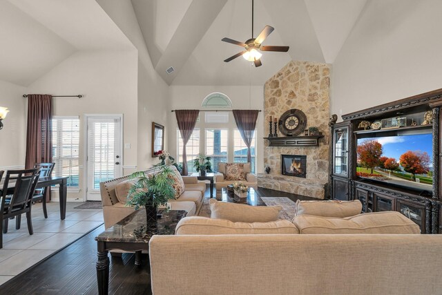 living room with a fireplace, dark hardwood / wood-style flooring, high vaulted ceiling, and ceiling fan