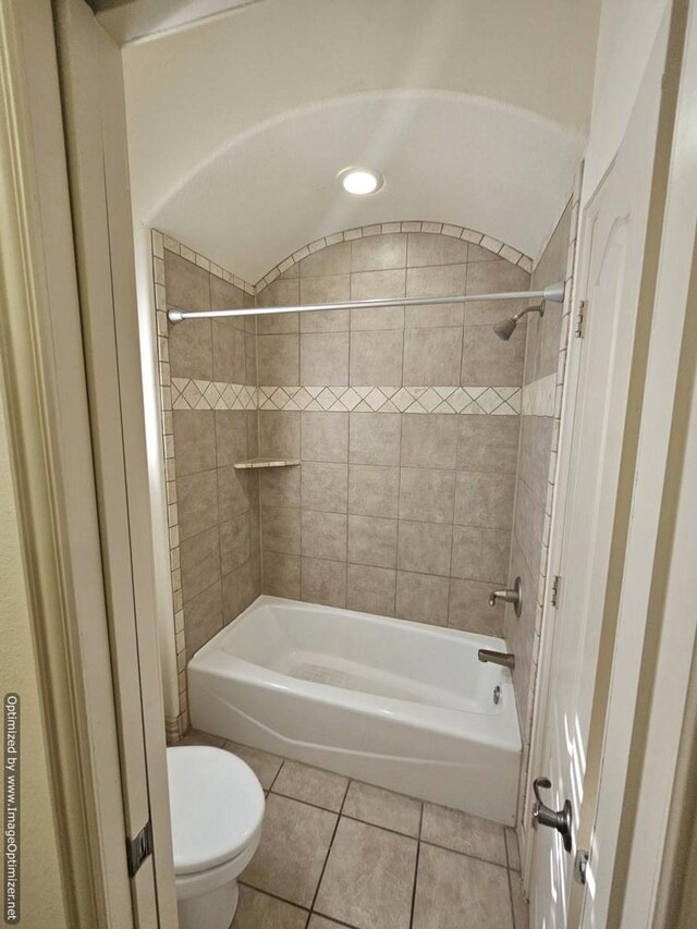 bathroom with tile patterned floors, toilet, and tiled shower / bath