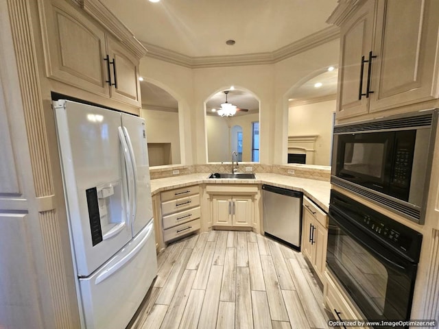 kitchen featuring light brown cabinetry, sink, black appliances, and light hardwood / wood-style floors