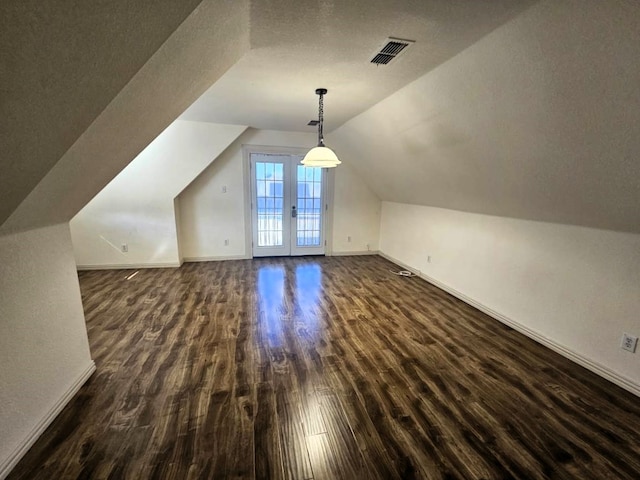 bonus room featuring dark hardwood / wood-style flooring, french doors, and lofted ceiling