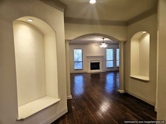 corridor featuring dark hardwood / wood-style flooring, decorative columns, and ornamental molding