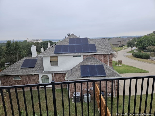 rear view of house featuring solar panels and central AC unit