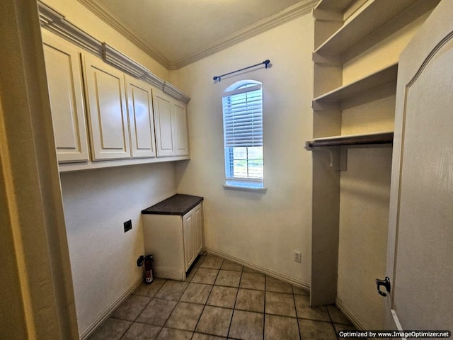 washroom featuring crown molding, cabinets, dark tile patterned flooring, and hookup for an electric dryer