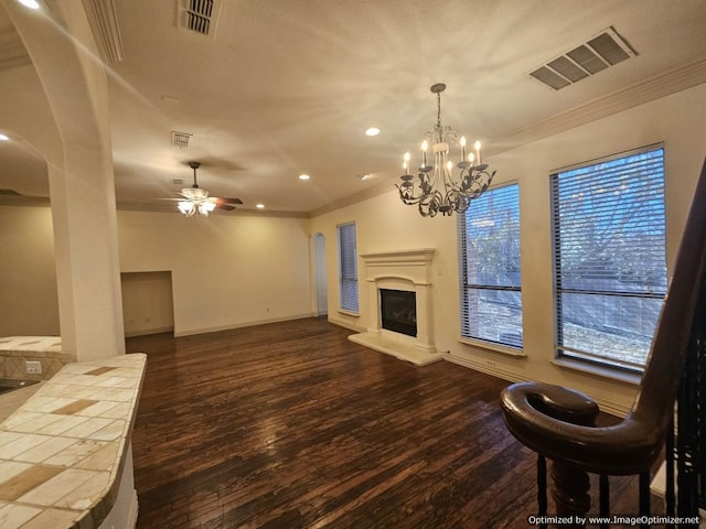 living room featuring crown molding, plenty of natural light, dark hardwood / wood-style floors, and ceiling fan with notable chandelier