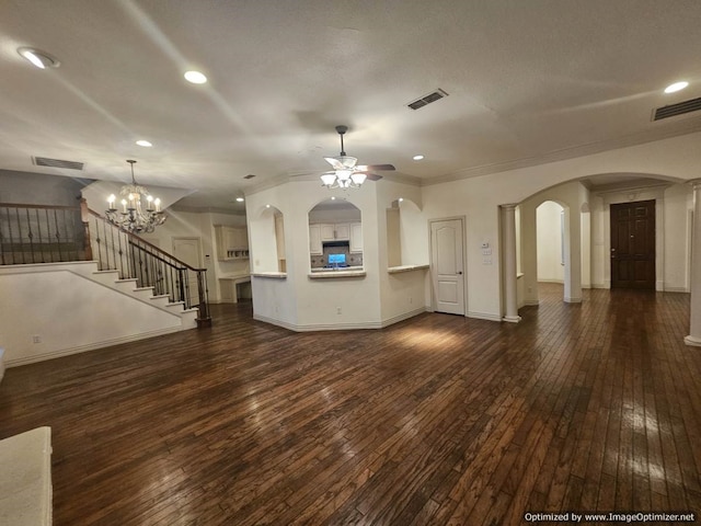 unfurnished living room with ceiling fan with notable chandelier, crown molding, and dark wood-type flooring