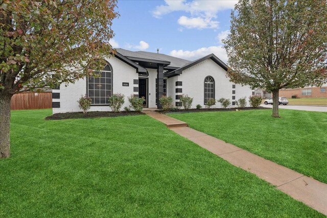 ranch-style home with a front lawn