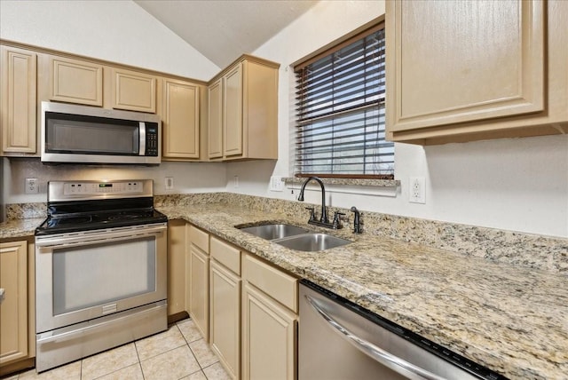 kitchen featuring sink, light brown cabinets, stainless steel appliances, vaulted ceiling, and light tile patterned floors