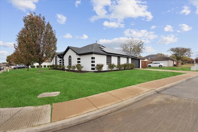 view of front of home featuring solar panels and a front lawn