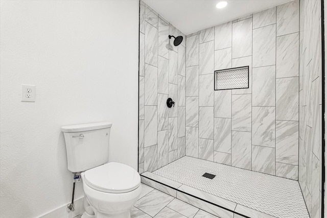 bathroom with toilet and a tile shower