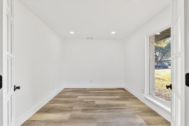 empty room featuring light wood-type flooring and a healthy amount of sunlight