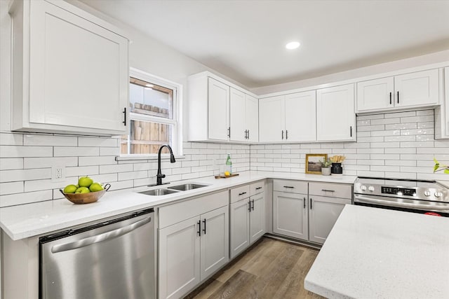 kitchen with backsplash, wood-type flooring, sink, light stone countertops, and stainless steel appliances