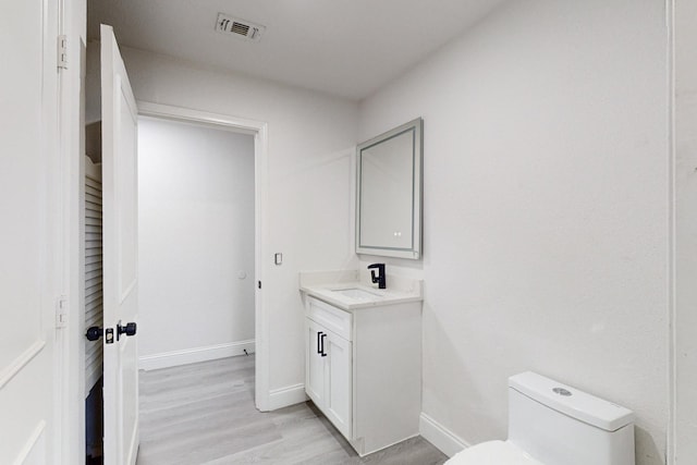 bathroom featuring hardwood / wood-style floors, vanity, and toilet