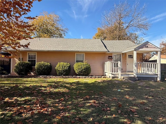 ranch-style home featuring a front lawn and covered porch