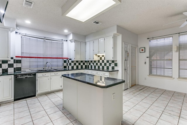 kitchen featuring sink, dishwasher, white cabinets, a kitchen island, and light tile patterned flooring